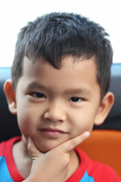 Ein asiatischer Junge von etwa fünf Jahren saß glücklich lächelnd