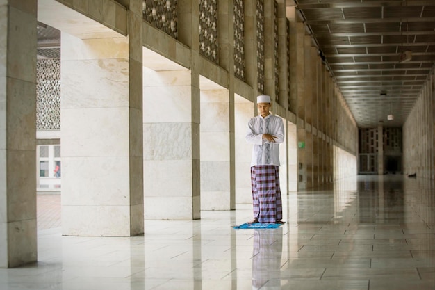 Ein asiatischer Mann, der auf der Istiqlal-Moschee salat macht