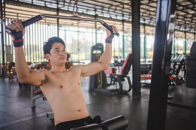 Foto ein asiatischer mann trainiert mit einer hantel im fitnessstudio