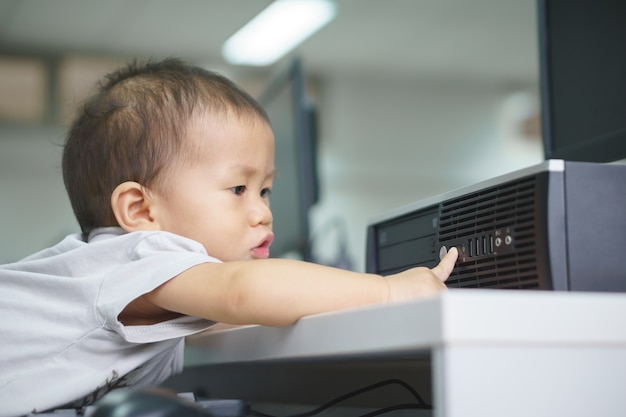 Ein asiatisches Baby, das versucht, Tischrechner zu benutzen