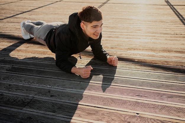 Ein Athlet, der eine Plank-Übung macht, ist gut für das Ganzkörpertraining auf der Straße in Weiß