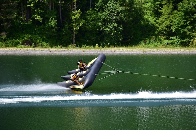 Ein aufblasbares Sportfloß mit zwei Mann schwebt schnell durch das Wasser und bricht sich fast davon ab