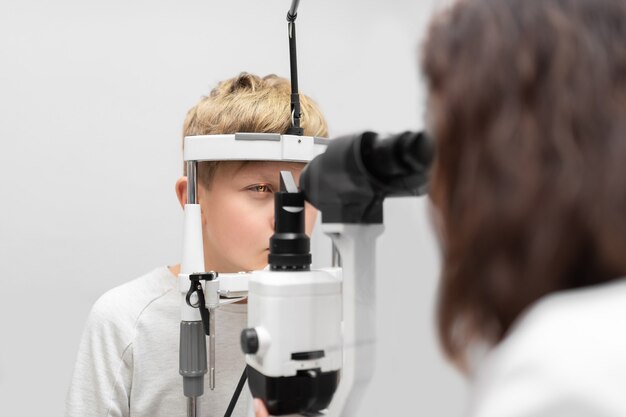 Ein aufmerksamer Augenarzt untersucht einen Patienten mit einer Spaltlampe in einer Augenklinik
