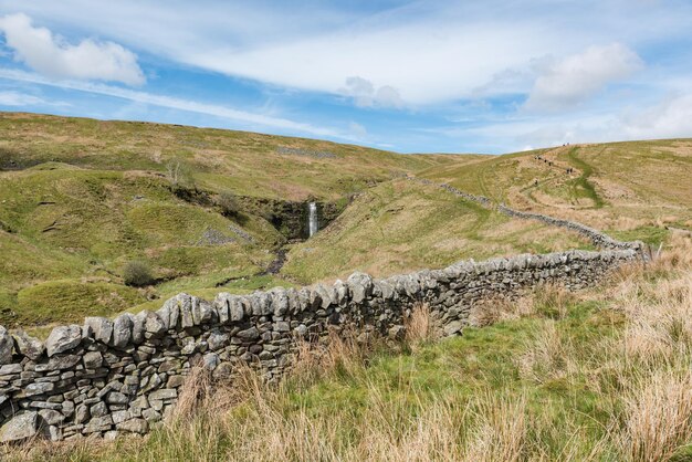 Foto ein aufstieg auf den whernside peak mit einem wasserfall in der ferne yorkshire drei gipfel herausforderung