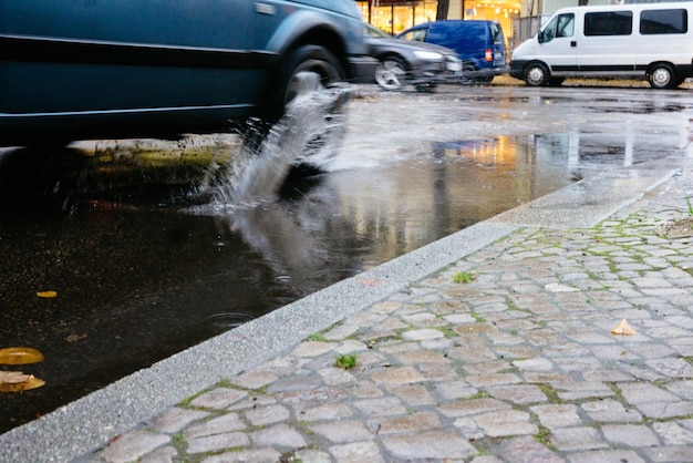 Foto ein auto spritzt wasser, während es auf einer pfütze fährt