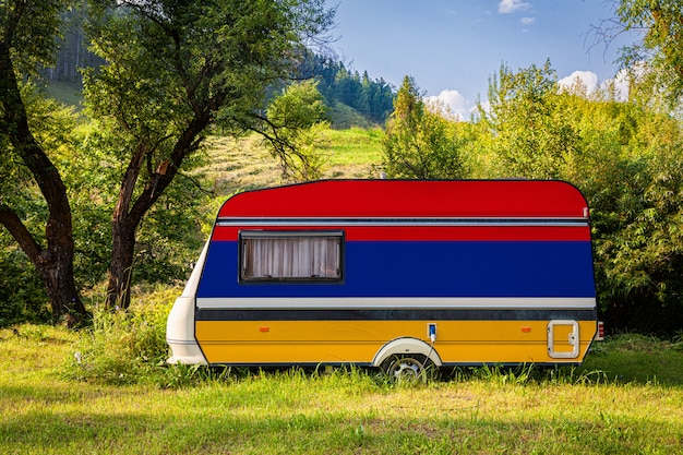 Foto ein autoanhänger, ein wohnmobil, gemalt in der armenischen nationalflagge, steht in einem bergpark.