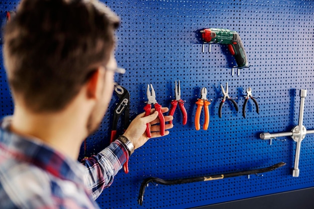 Foto ein automechaniker, der eine zange nimmt, um ein auto in der garage zu reparieren