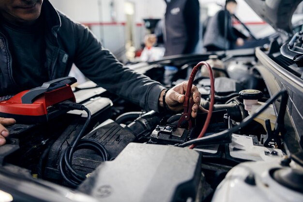 Ein Automechaniker führt bei mechanic39s eine Batteriediagnose an einem Auto durch