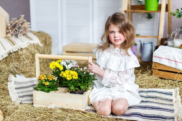 Ein Baby, das schöne Blumen sitzt und hält