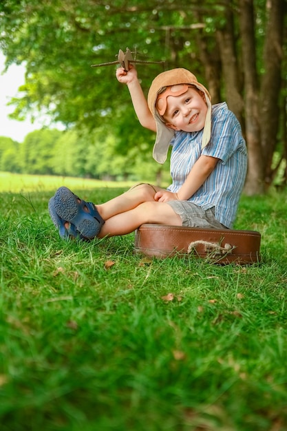 Ein Baby im Flugzeug spielt mit der Natur im Park. Junge im Urlaub Pilot.