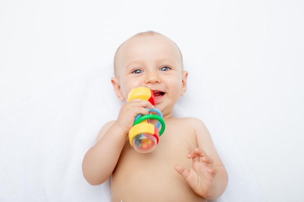 Ein Baby in einer Windel mit Spielzeug liegt auf einem weißen Hintergrund isoliert