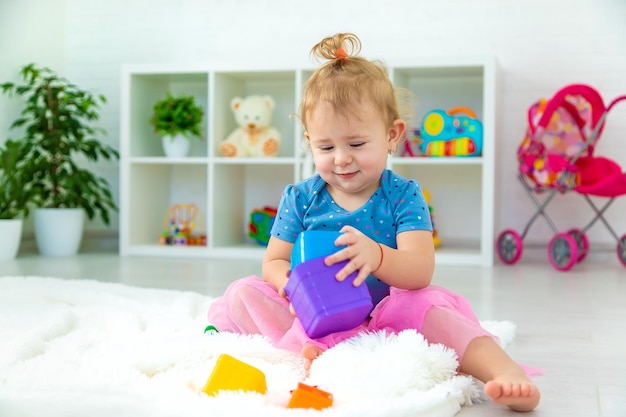 Ein Baby Kind spielt mit Spielzeug im Spielzimmer Selektiver Fokus Kid