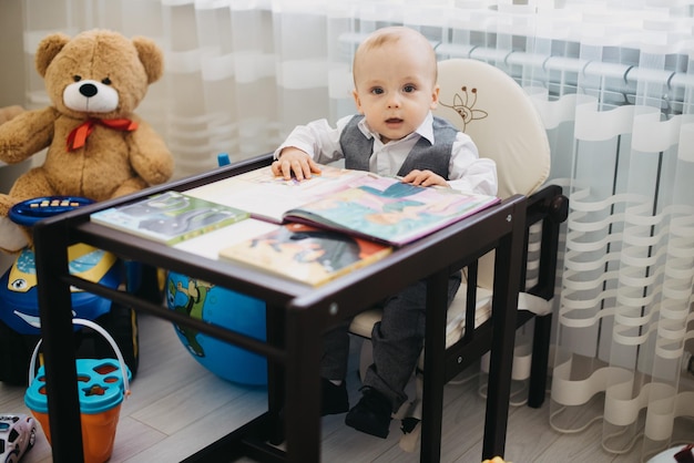 Ein Baby sitzt in einem Hochstuhl mit einem Buch darauf.