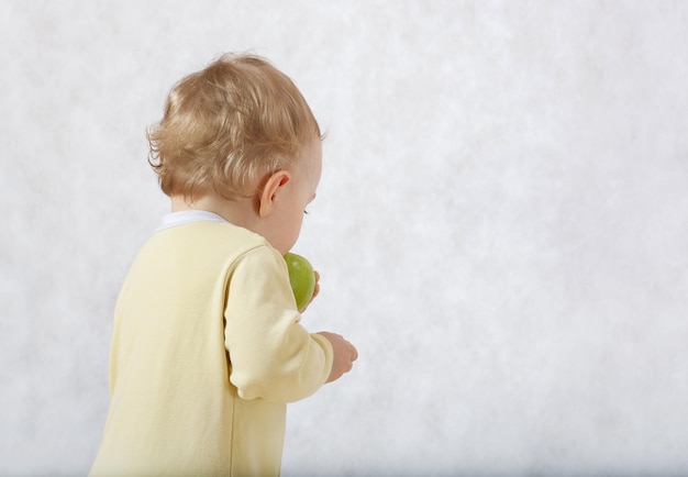 Ein Baby versucht, seinen Faustsnack zu essen. Freier Platz für einen Text