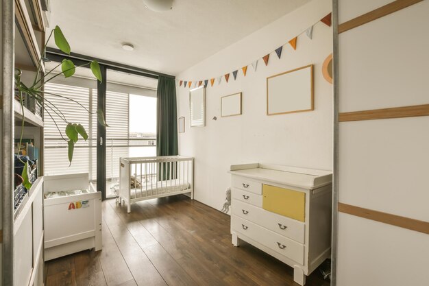 ein Babyzimmer mit Wiege und Kommode