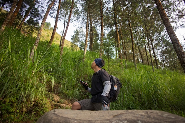 Ein Backpacker-Mann reist alleine mit einem Rucksack in den Bergen