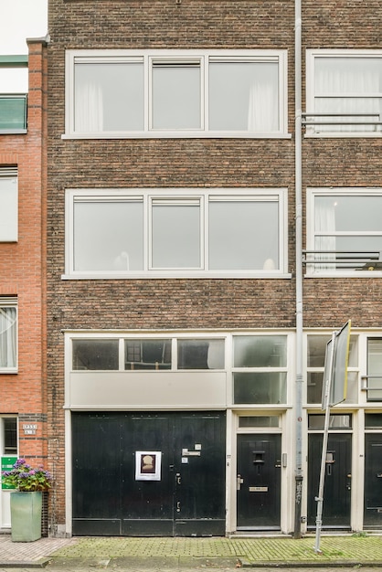 Ein Backsteingebäude mit einer schwarzen Tür und Fenstern