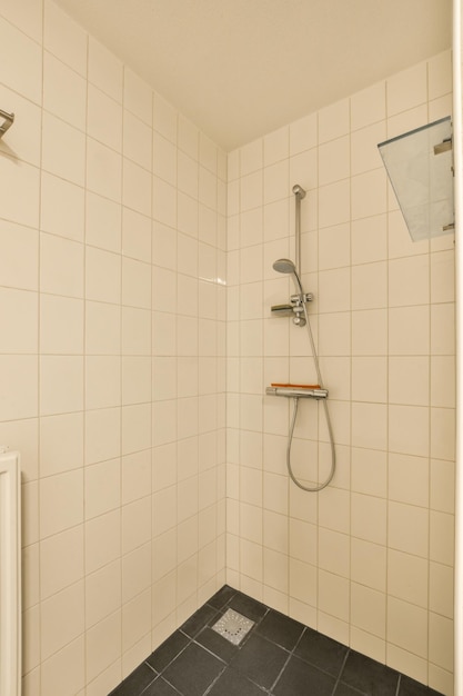 Foto ein badezimmer mit fliesenwänden und schwarzem fliesenboden an der duschwand gibt es eine toilette in der ecke
