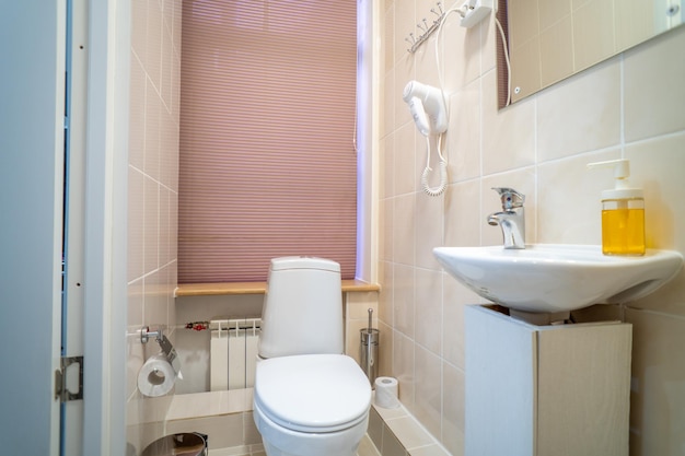 Ein Badezimmer mit Toilette und Waschbecken mit Handtuchhalter.