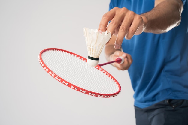Ein Badmintonspieler in Sportkleidung steht mit Schläger und Federball
