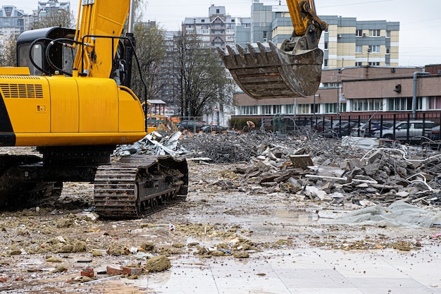 Ein Bagger unter einem Müllhaufen, nachdem er ein illegal errichtetes Gebäude demontiert hat.