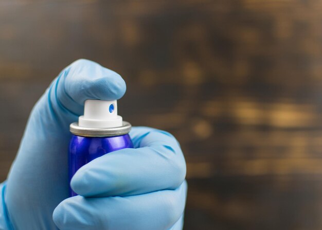 Ein Ballon mit einem Aerosolspray in der Hand auf dunklem Hintergrund