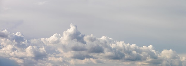 Ein Band aus weißen, lockigen Wolken in sanften Blaugrautönen