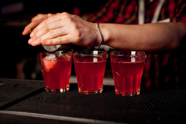 Ein Barkeeper macht an der Bar einen Cocktail mit Alkohol in einer Bar. Das Konzept des Nachtlebens.