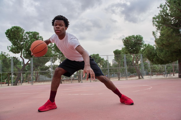 Ein Basketballspieler trainiert auf einem Platz in der Stadt