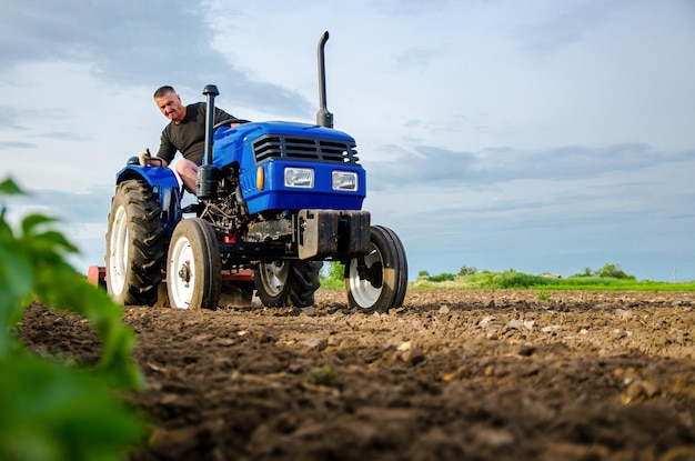 Ein Bauer auf einem Traktor bearbeitet das Feld Fräserde, zerkleinert und lockert den Boden, bevor er Reihen schneidet