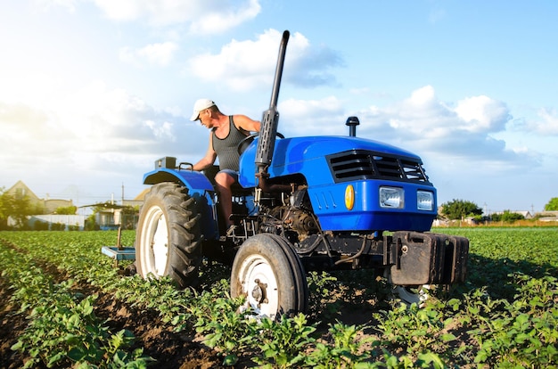 Ein Bauer auf einem Traktor bewirtschaftet eine Kartoffelplantage Agroindustrie und Agribusiness Feldarbeit Anbau Landmaschinen Arbeit auf dem Bauernhof Verbesserung der Bodenqualität Pflügen und Auflockern