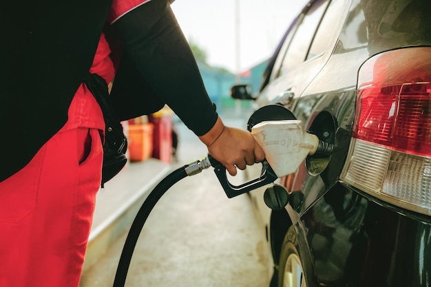Ein Beamter an einer Tankstelle bei der Betankung eines Autos