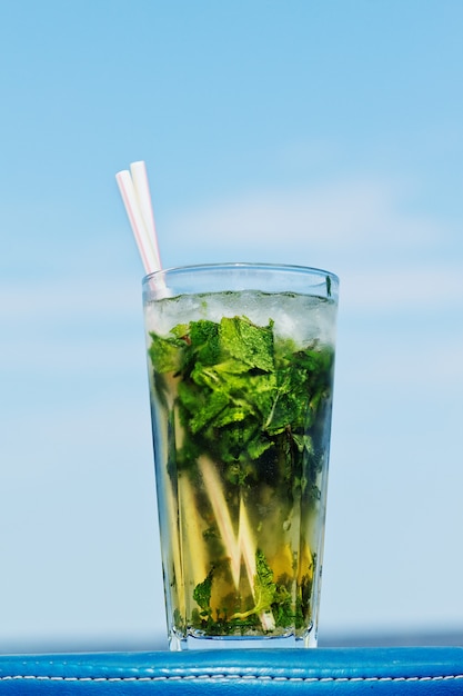 Ein beschlagenes Glas Cocktail Mojito über blauem Himmel