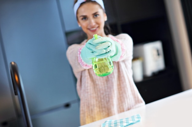 Ein Bild einer aufgeregten Frau, die die Küchenarbeitsplatte putzt