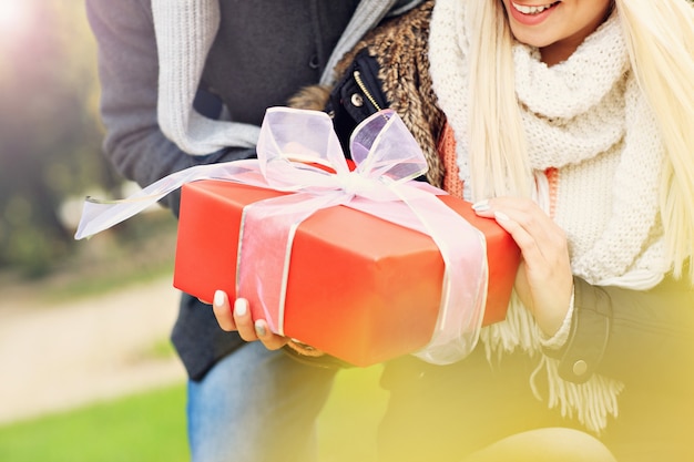 Ein Bild eines jungen Paares mit Geschenk im Park