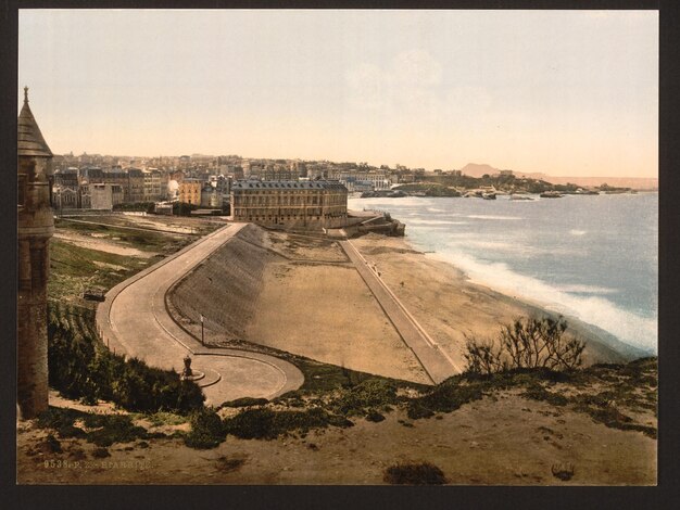 ein Bild eines Strandes mit einem Mann, der am Strand steht, und dem Ozean im Hintergrund