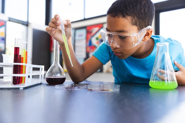 Ein Biracial-Junge nimmt an einem wissenschaftlichen Experiment in der Schule im Klassenzimmer teil