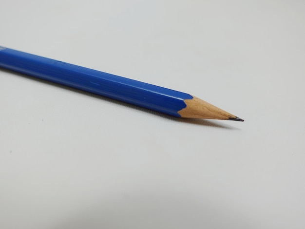ein blauer Bleistift mit gelber Spitze auf einer weißen Oberfläche.