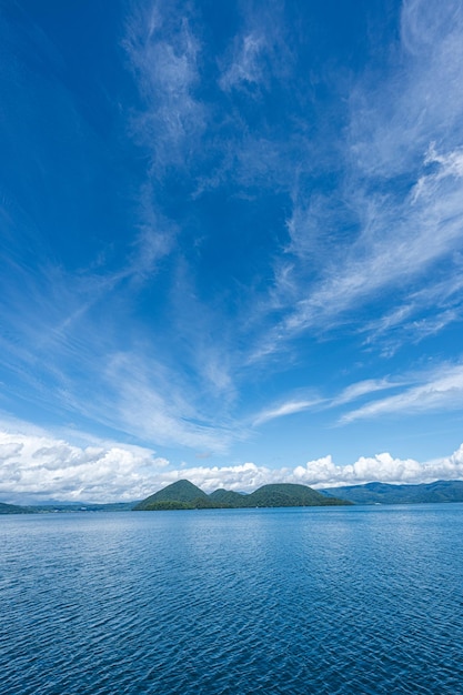 Ein blauer Himmel mit Wolken und einem Boot im Vordergrund