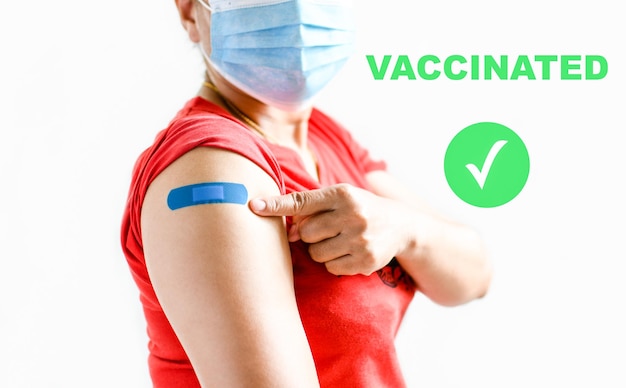 Ein blauer Pflaster ist am Arm der Frau befestigt Konzept für Erste Hilfe nach Coronavirus COVID-19 Impfung und professioneller medizinischer Nadel Blutkrebs Nahaufnahme weißer verschwommener Hintergrund