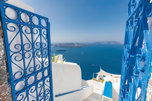 Ein Blick auf das Meer von einem weißen Haus mit blauen Türen und blauem Himmel.