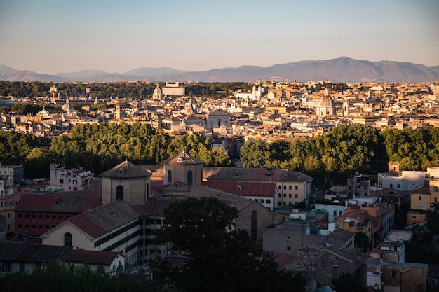 Ein Blick auf die Stadt Rom vom Hügel aus bei Sonnenuntergang mit Bergen im Hintergrund