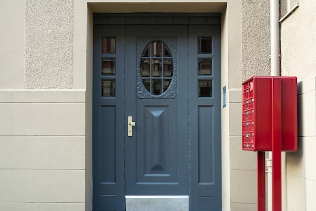 Ein Blick auf eine blaue Haustür und einen roten Briefkasten in einem Wohnhaus.