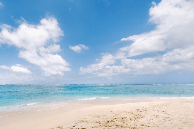 Ein Blick aus der Höhe eines tropischen Strandes und der Wellen, die an einem tropischen goldenen Sandstrand brechen. Die Meereswellen winden sich sanft am schönen Sandstrand entlang.