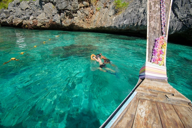 Ein Blick vom thailändischen traditionellen Langschwanzboot, während Touristen schnorcheln und im Ozean tauchen, Phi Phi Islands, Thailand