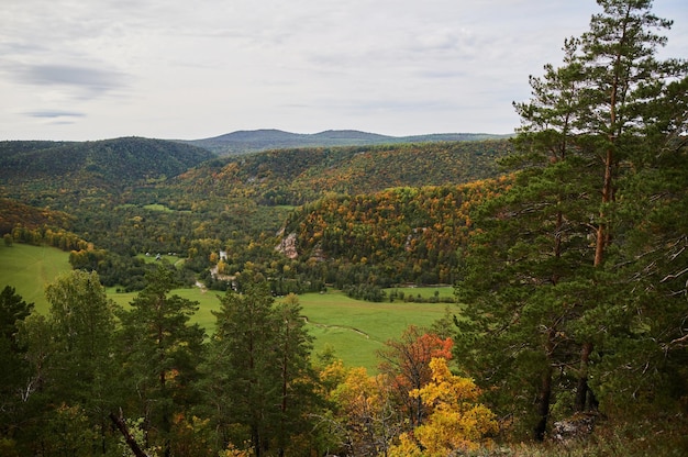 Ein Blick von oben auf bunte Waldbäume und den See in der Herbstsaison