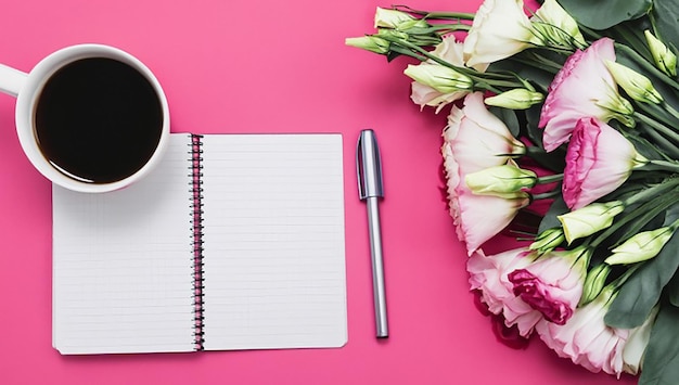 Ein Blick von oben auf Eustoma-Blüten mit Tagebuch, Stift und Kaffeetasse auf rosa Hintergrund.