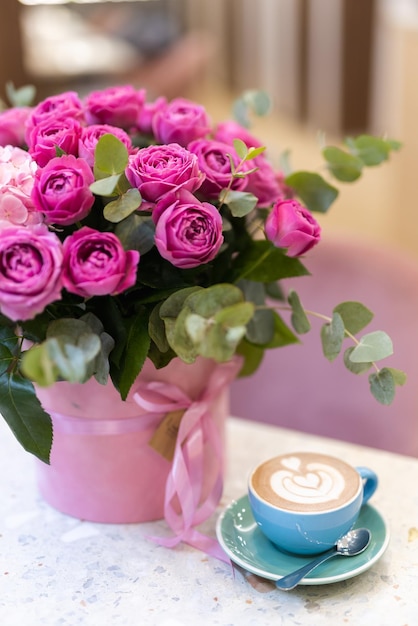 Ein Blumenstrauß auf dem Tisch und eine Tasse Kaffee