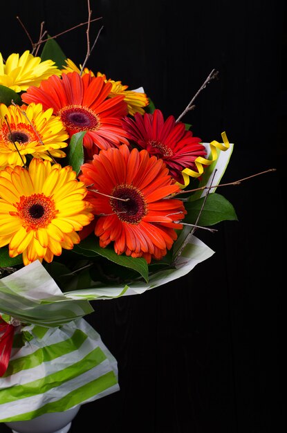 Ein Blumenstrauß auf einem dunklen hölzernen Hintergrund. Strauß mit Rosen.