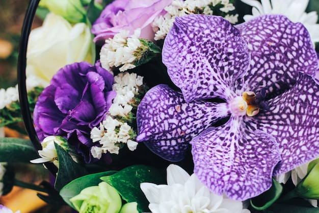 Ein Blumenstrauß in lila Tönen mit einer Tigerorchidee in der Mitte. Ansicht schließen